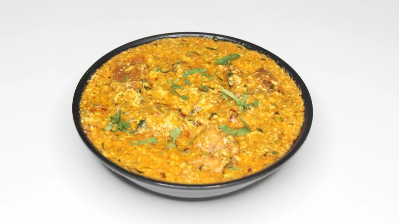 Patiyala served in a black bowl, garnished with coriander